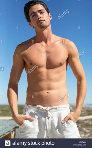 Shirtless man standing with hands in pockets Stock Picture